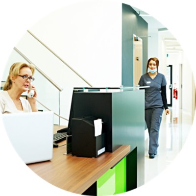 Woman on phone in front of a computer at reception desk