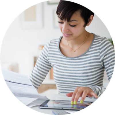 Woman looking at paper and tablet