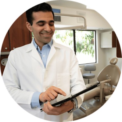 Dental Claim Attachments - dentist smiling as he looks at tablet