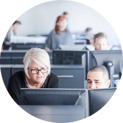 Advanced Claim Management - coworkers in discussion whilst looking at computer screen