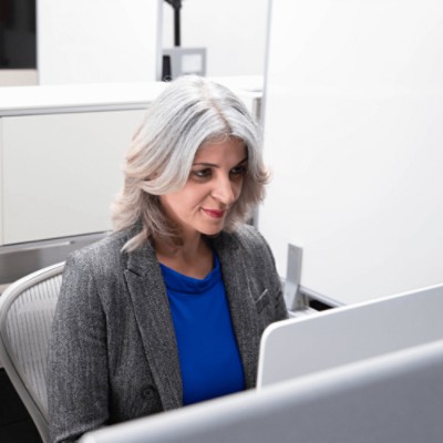 Woman in cubicle using computer