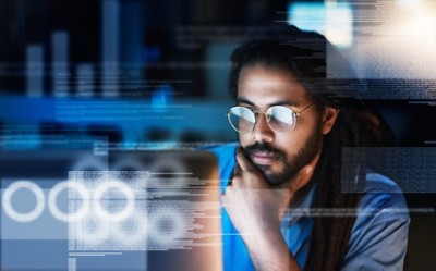 Shot of a programmer working on a computer code at night