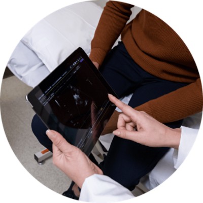 Healthcare Transformation Solutions - doctor with patient pointing at x-ray on tablet 