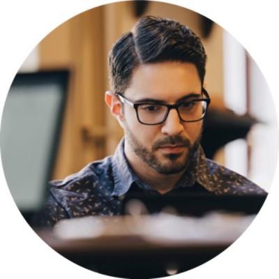 man in glasses looking at computer