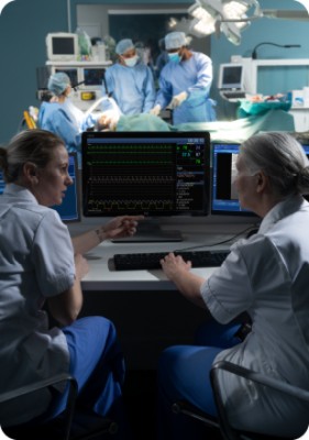 Doctor and patient discussing scans on screen while surgery performed in background